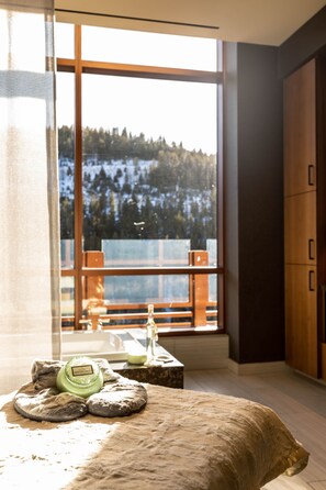 A room with a large window, wooden cabinets, and a small table with a bottle and a candle. - Monarch Casino Resort Spa Black Hawk (Black Hawk)