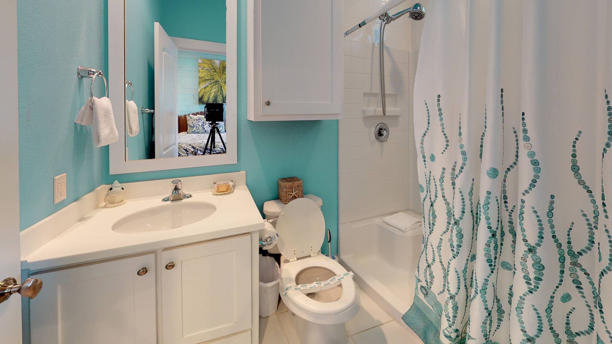 A bathroom with a white sink, a toilet, and a shower with a curtain.