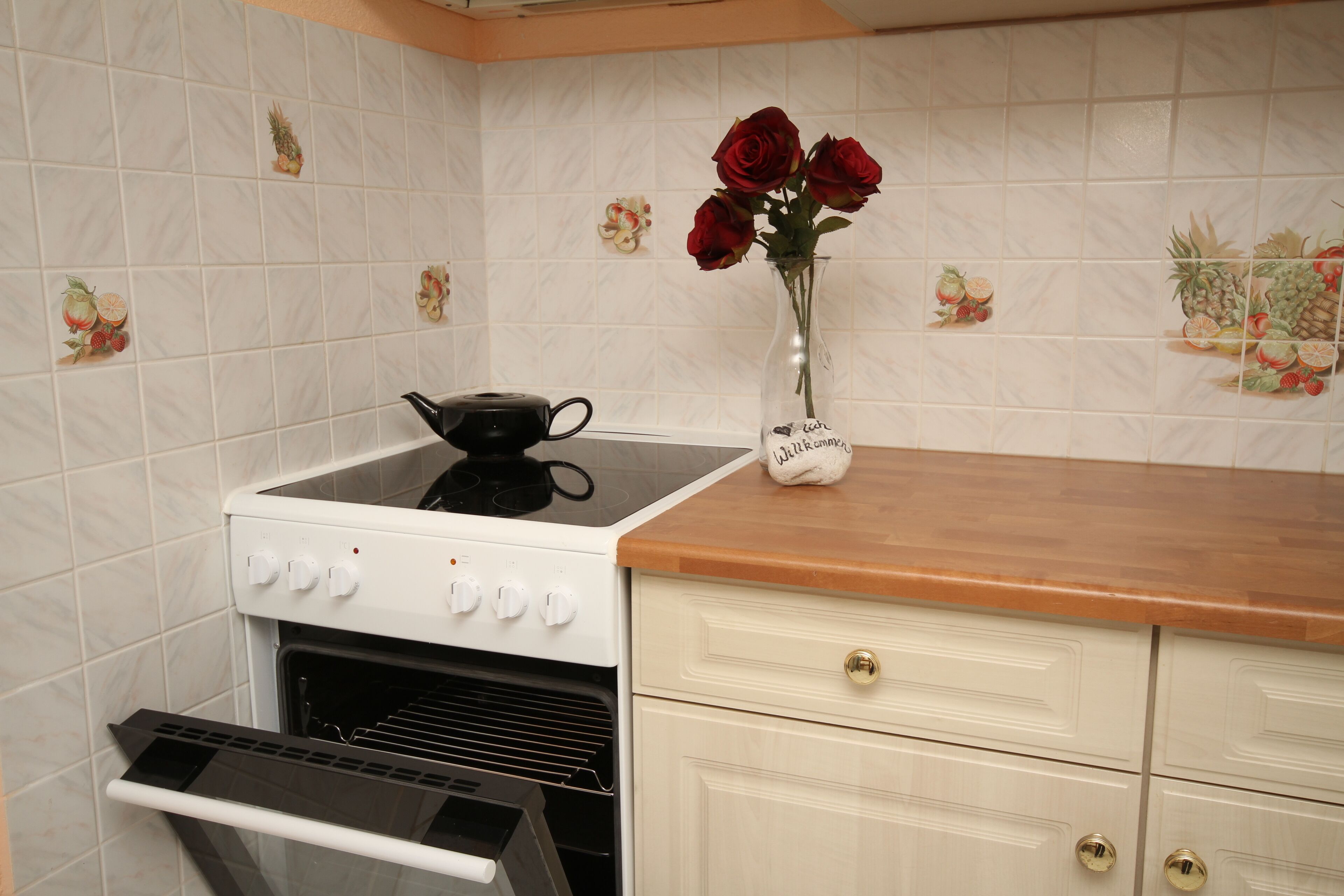 Una cocina con estufa blanca, horno y encimera de madera.