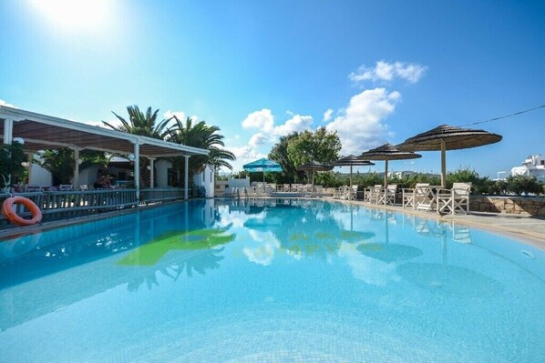 En säsongsöppen utomhuspool, parasoller och solstolar