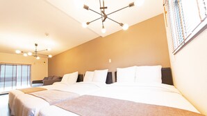 Een hotelkamer met een groot bed, een plafondlamp en een raam met zonwering.