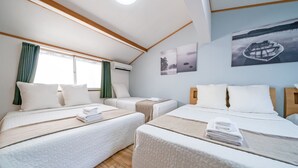 A hotel room with two beds, a large window with curtains, and artwork on the wall. - TWS Morinomiya (Osaka)