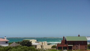 A coastal view with buildings and the sea. - Silverdunes Holiday Accommodation (Betty's Bay)