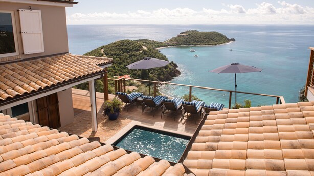 Una piscina en la azotea con vistas al mar y una pequeña isla.