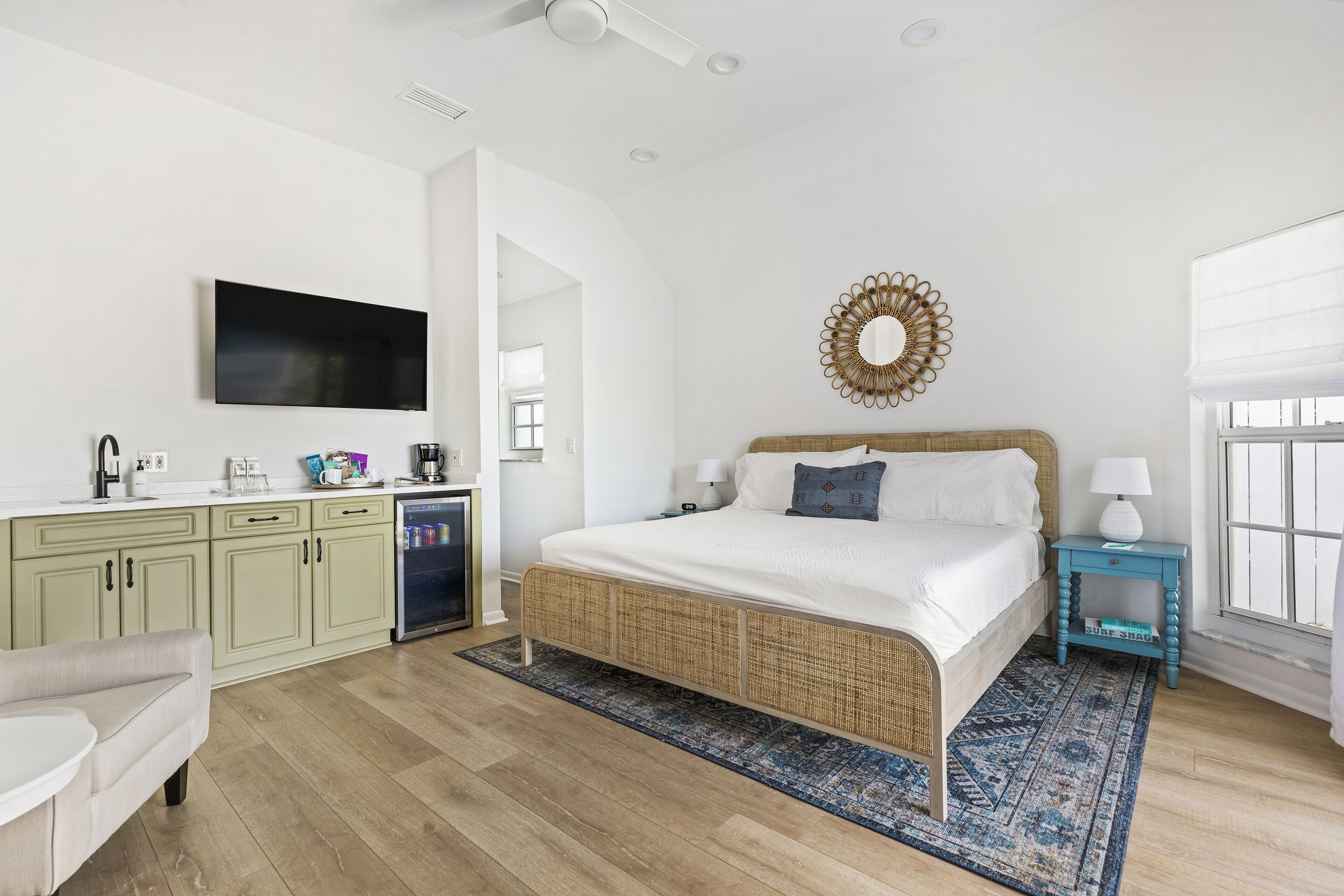 A bedroom with a bed, a TV, a dresser, and a window.