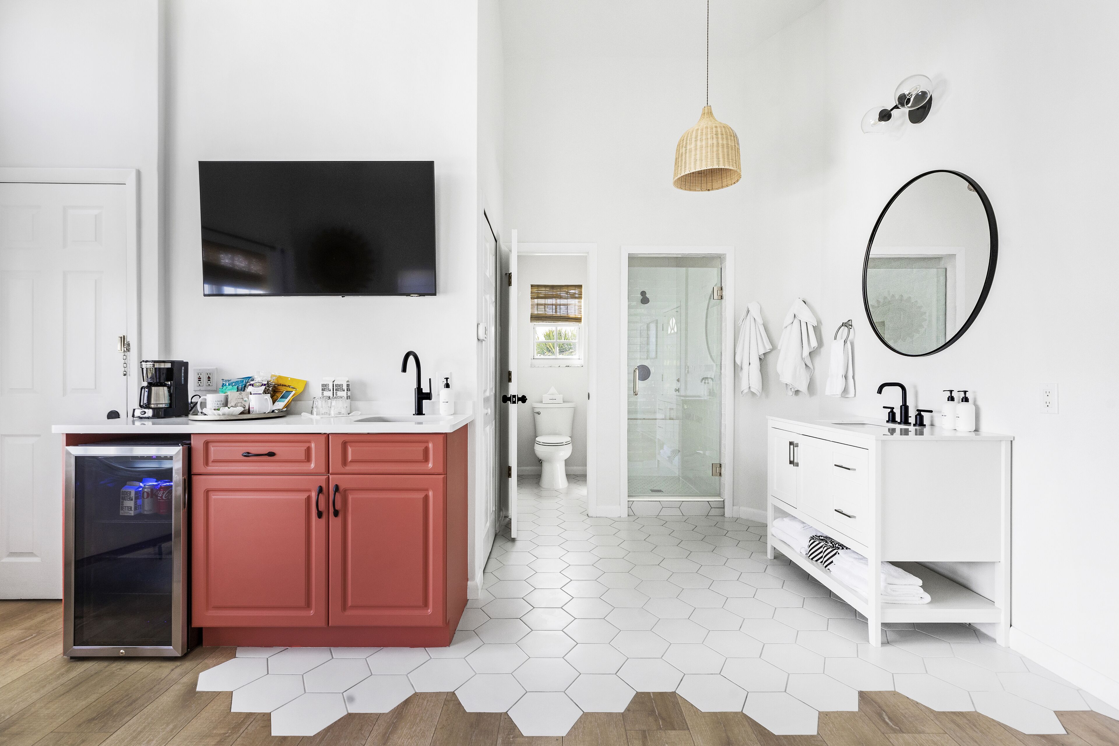 Un baño moderno con un lavabo blanco, un espejo y una cabina de ducha de vidrio.