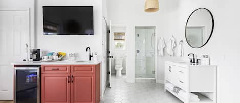 Un baño moderno con un lavabo blanco, un espejo y una cabina de ducha de vidrio.