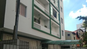 Un edificio a più piani con balconi, un ingresso carrabile e un piano terra piastrellato.