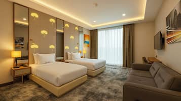 A hotel room with two beds, a sofa, a large mirror, and a painting on the wall.
