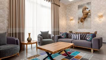 Un salon moderne avec un canapé, des fauteuils, une table basse et un tapis.