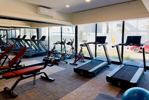 Una palestra con tapis roulant, macchinari per pesi e palle da ginnastica.