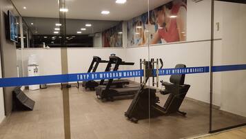 A gym with treadmills, exercise equipment, and a water dispenser.
