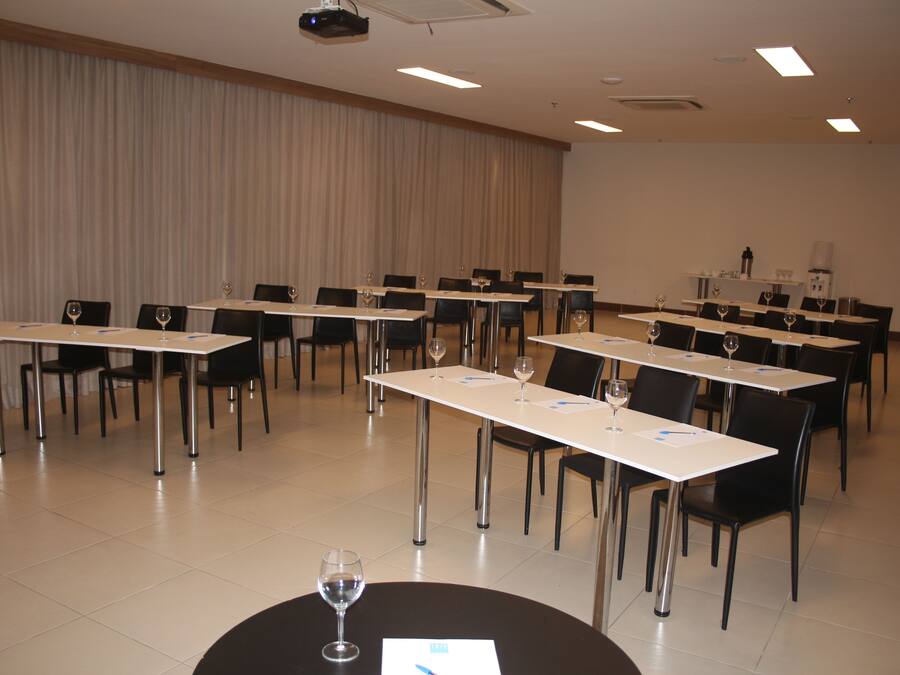 A conference room with tables, chairs, and a projector.