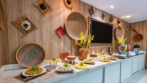 Un bufé con diversos platos y una amplia pared decorativa con cestas tejidas y colgadores.