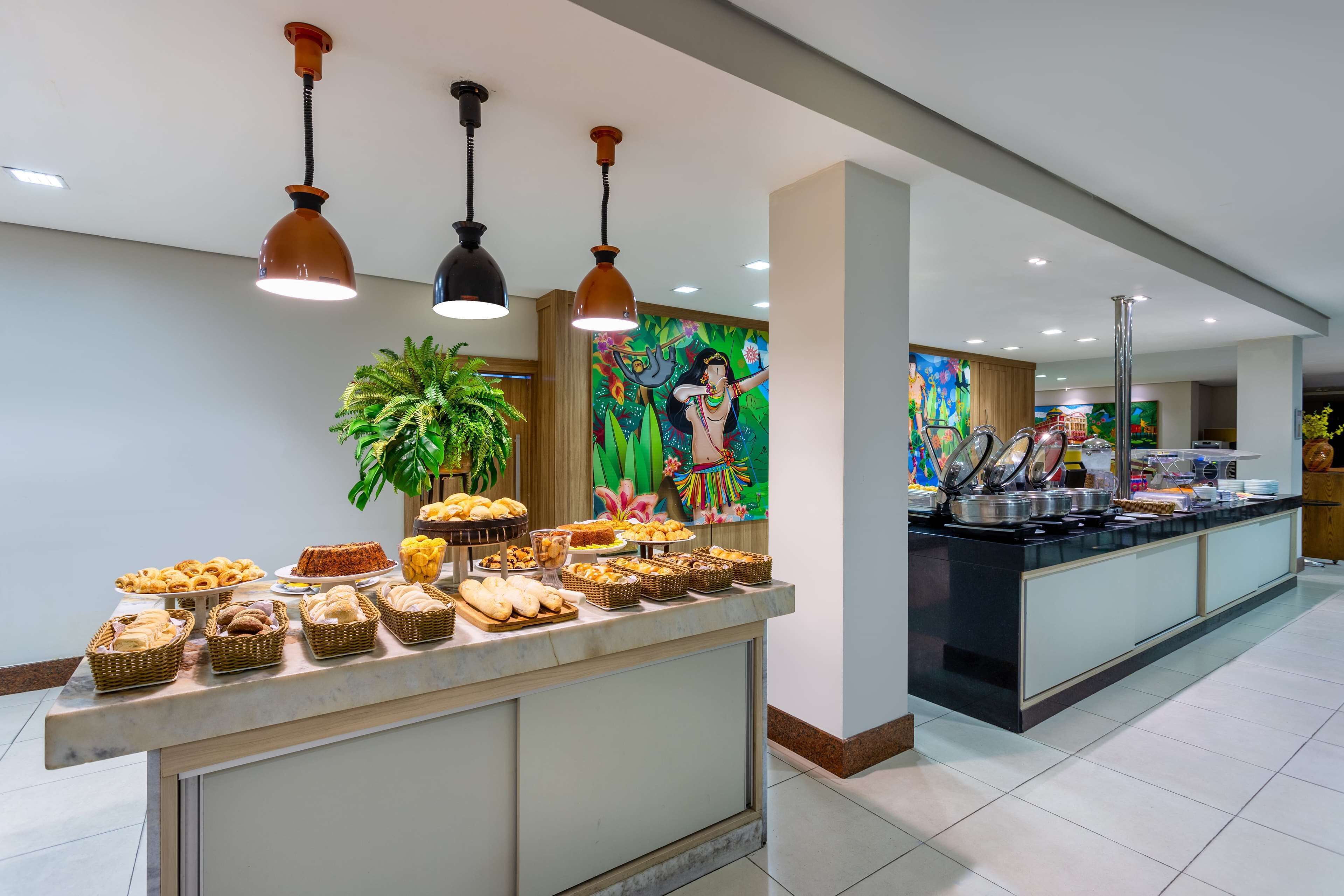 A buffet area with various food items and a colorful mural on the wall.