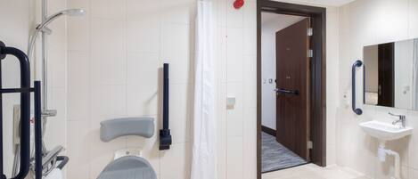 A modern bathroom with a shower, toilet, and sink.