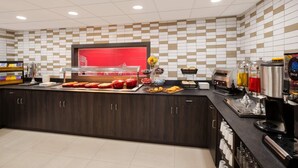 A modern kitchen with a buffet counter, various food items, and a coffee station. - Ramada by Wyndham Leeds East (Leeds)