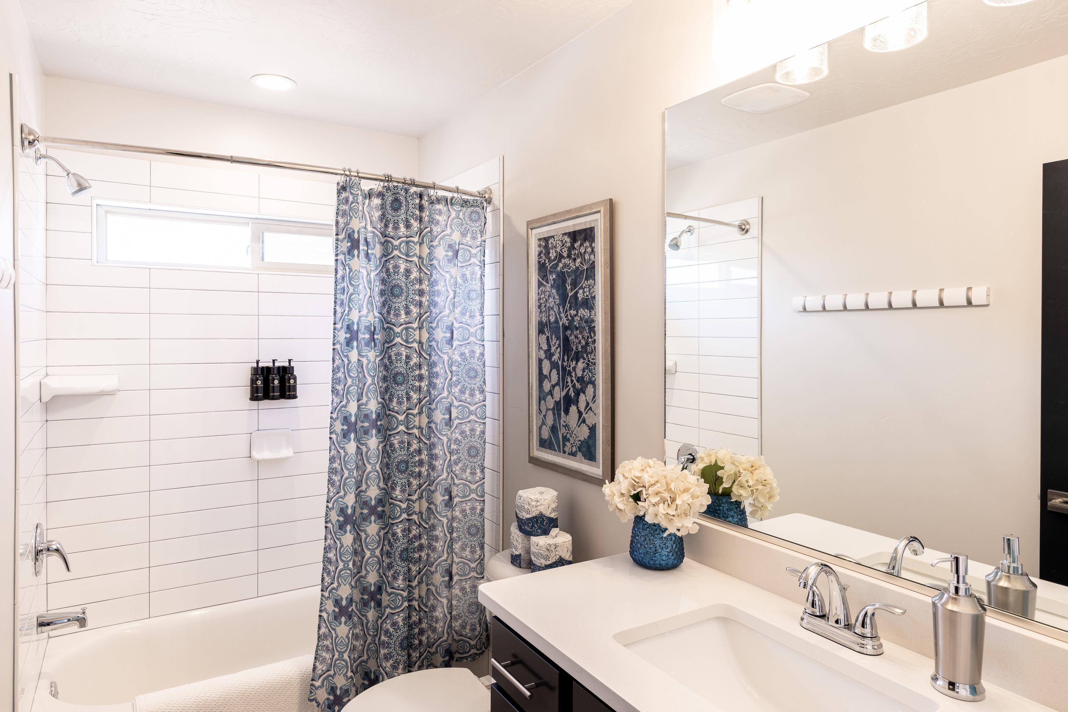 A modern bathroom with a shower, toilet, and sink.