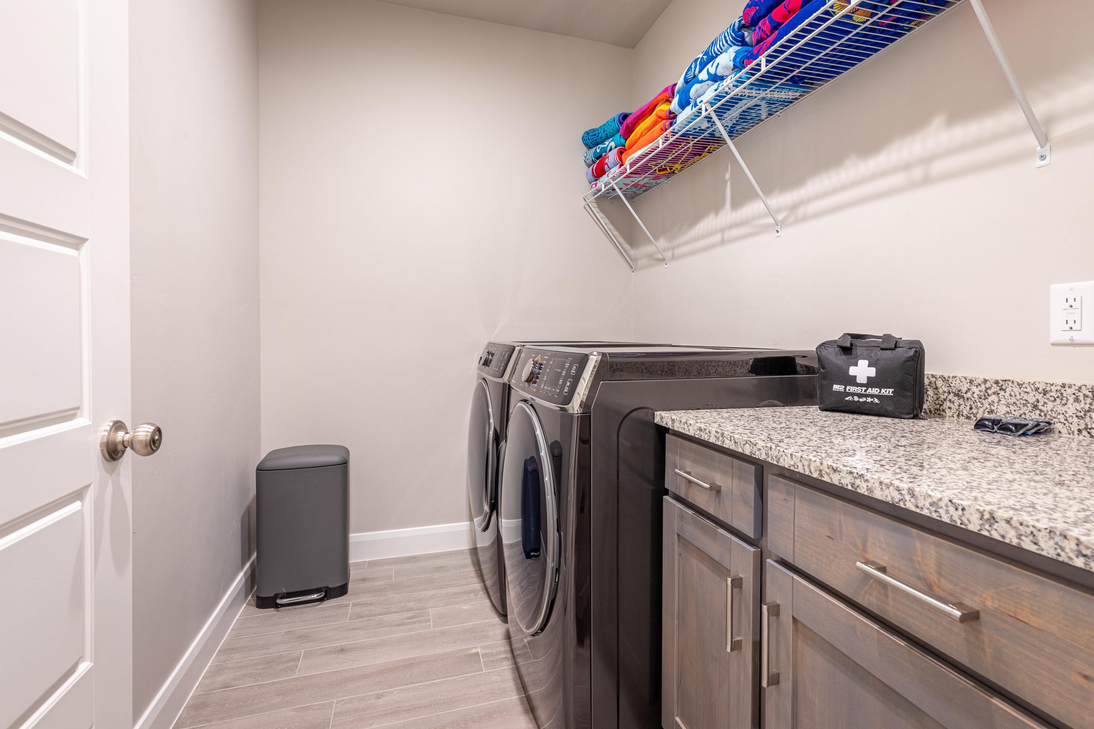 A laundry area with a washing machine, dryer, and a drying rack.