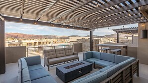 An outdoor patio with seating, a fire pit, and a view of mountains. - Poolside Paradise (St. George)