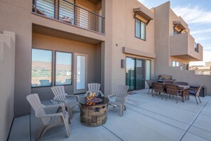 An outdoor patio with a fire pit, chairs, and a dining table. - Launchpad (St. George)