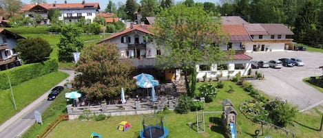 Zona residencial con un parque infantil, un trampolín y un pequeño edificio con un tobogán.