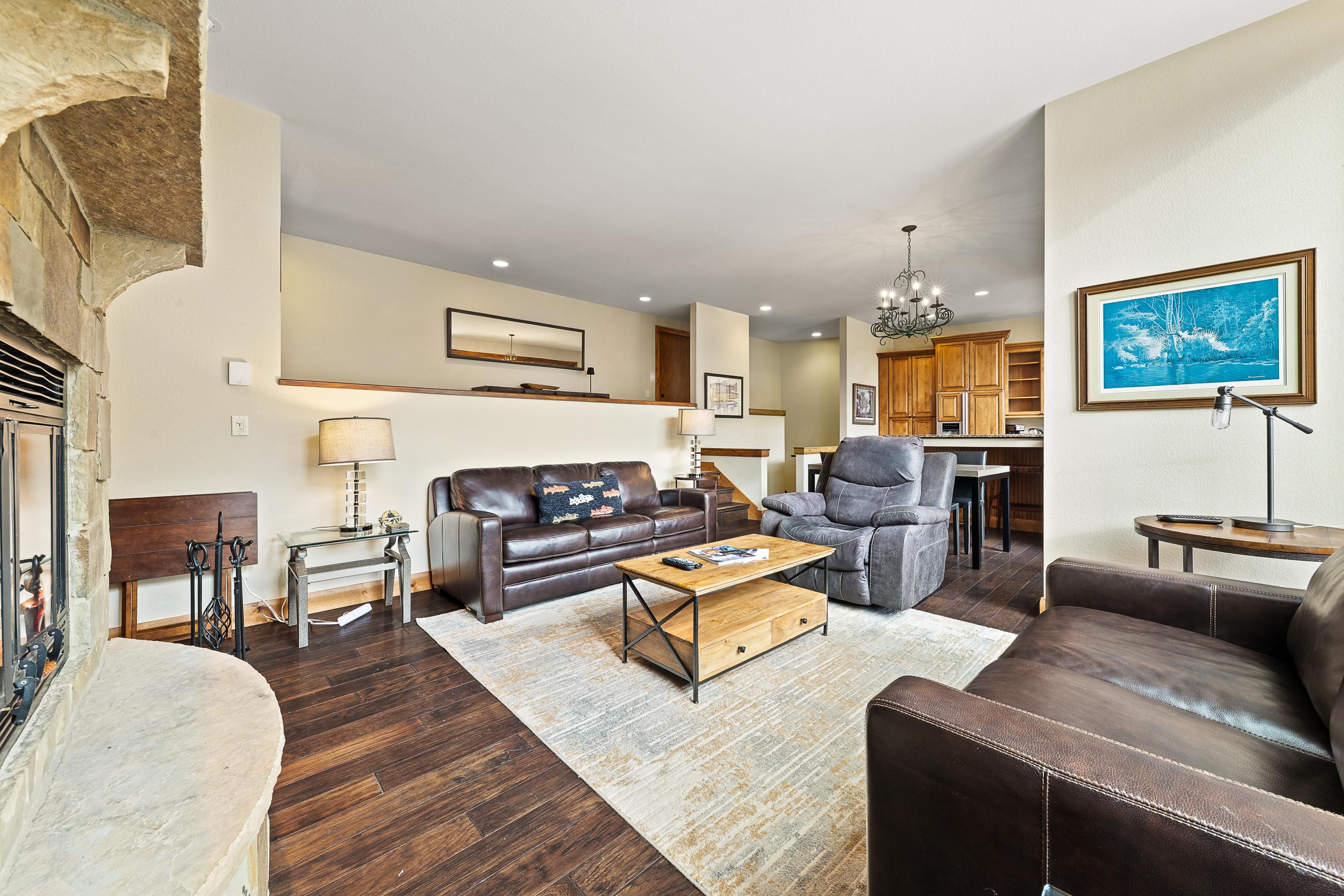 A modern living room with a leather sofa, a coffee table, and a fireplace.