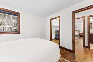 A bedroom with a bed, a window, and a mirror.