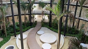 A multi-level atrium with a central pathway surrounded by planters and seating areas. - Trendy Studio, PANORAMIC D 202 – By Salt-Kisses (Tulum)