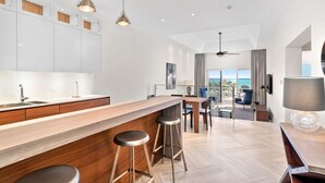 Una cocina moderna con barra de madera, taburetes y lámparas colgantes.