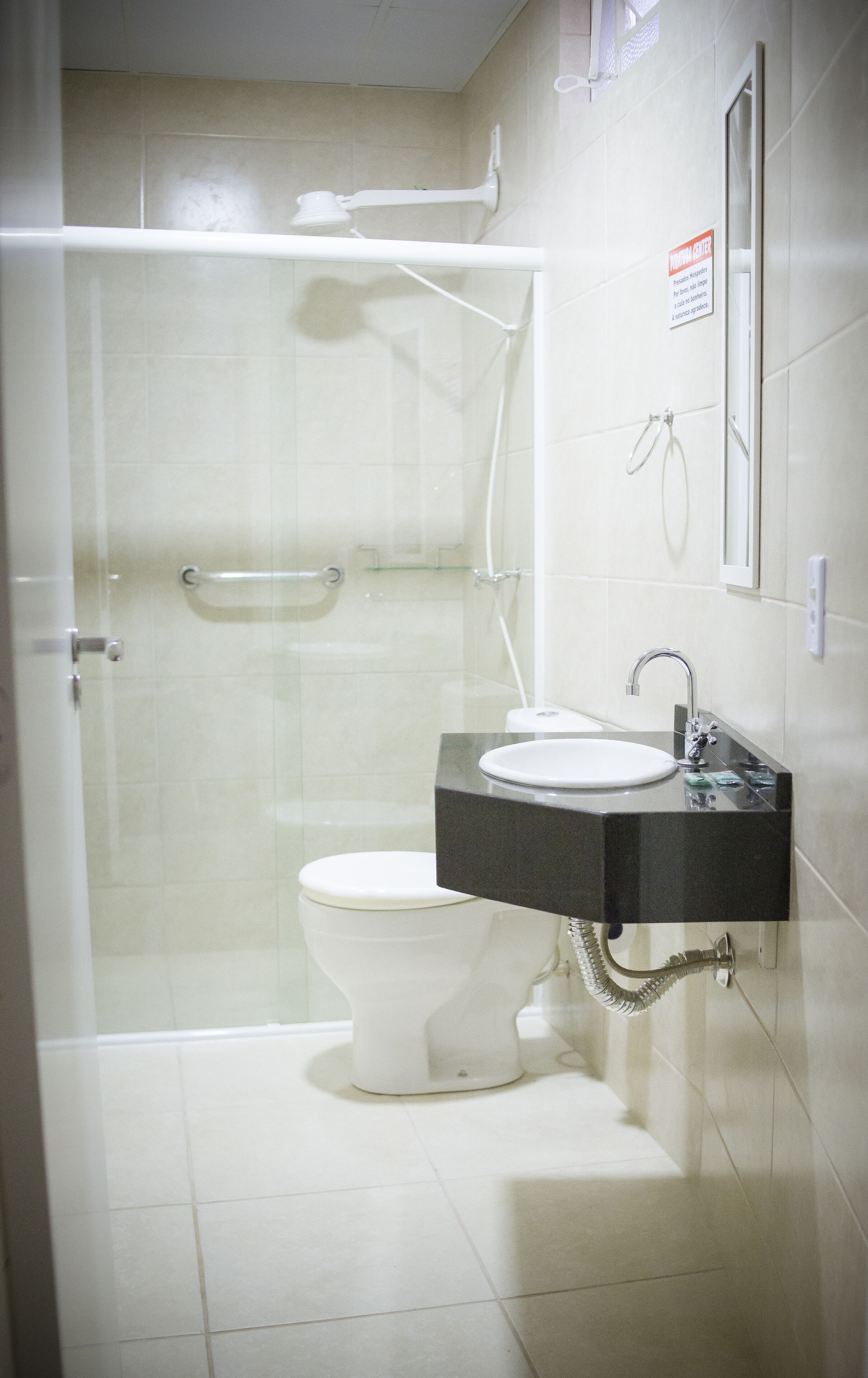 Un baño con inodoro, lavamanos y ducha.