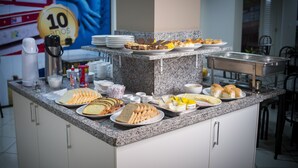 Un mostrador de buffet con diversos alimentos y utensilios.