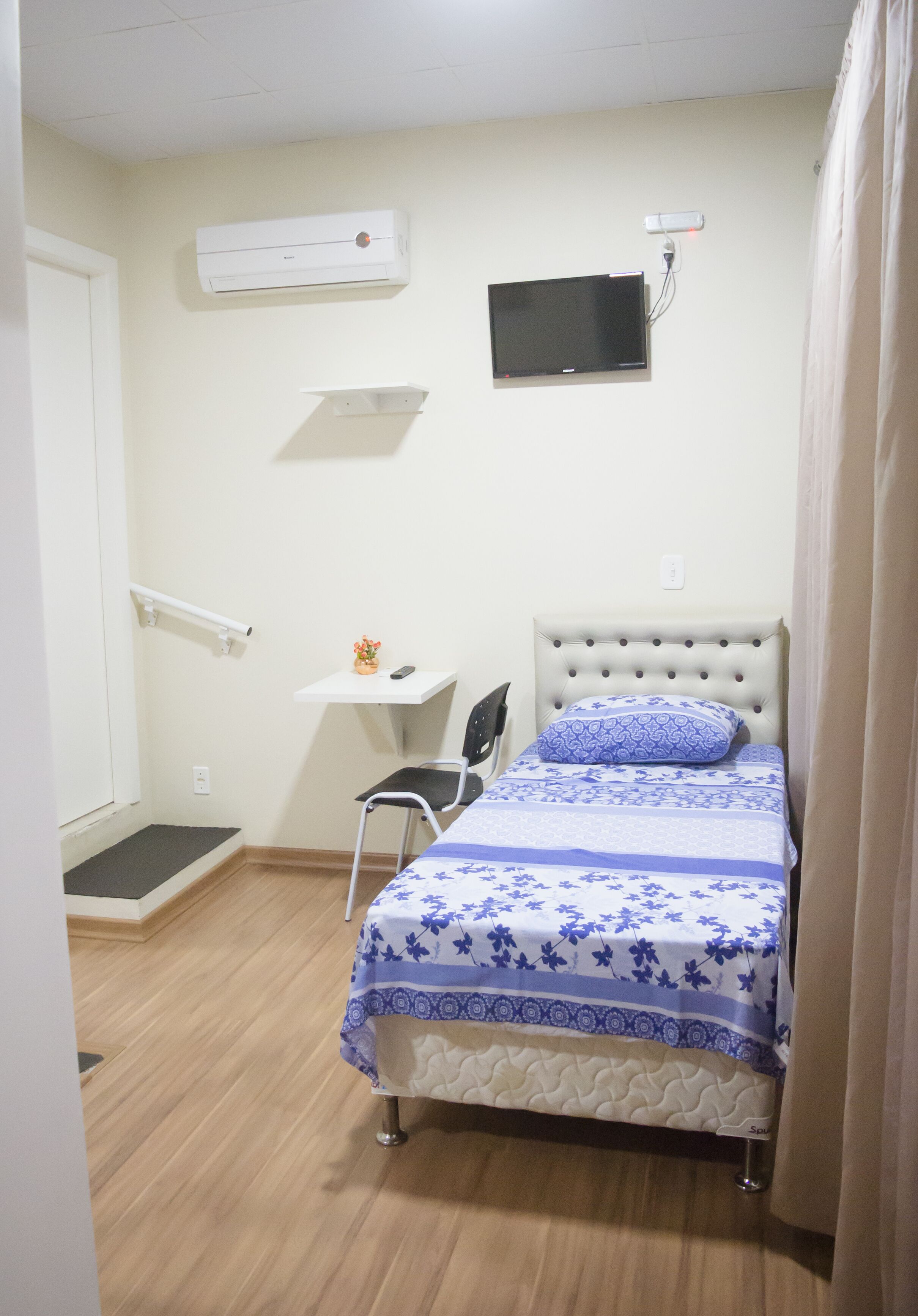 Une chambre à coucher avec un lit, un bureau et une télévision.