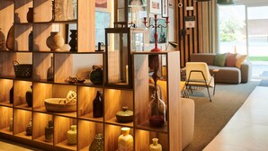 Een modern interieur met een houten open kast, hanglampen en een zithoek met uitzicht.