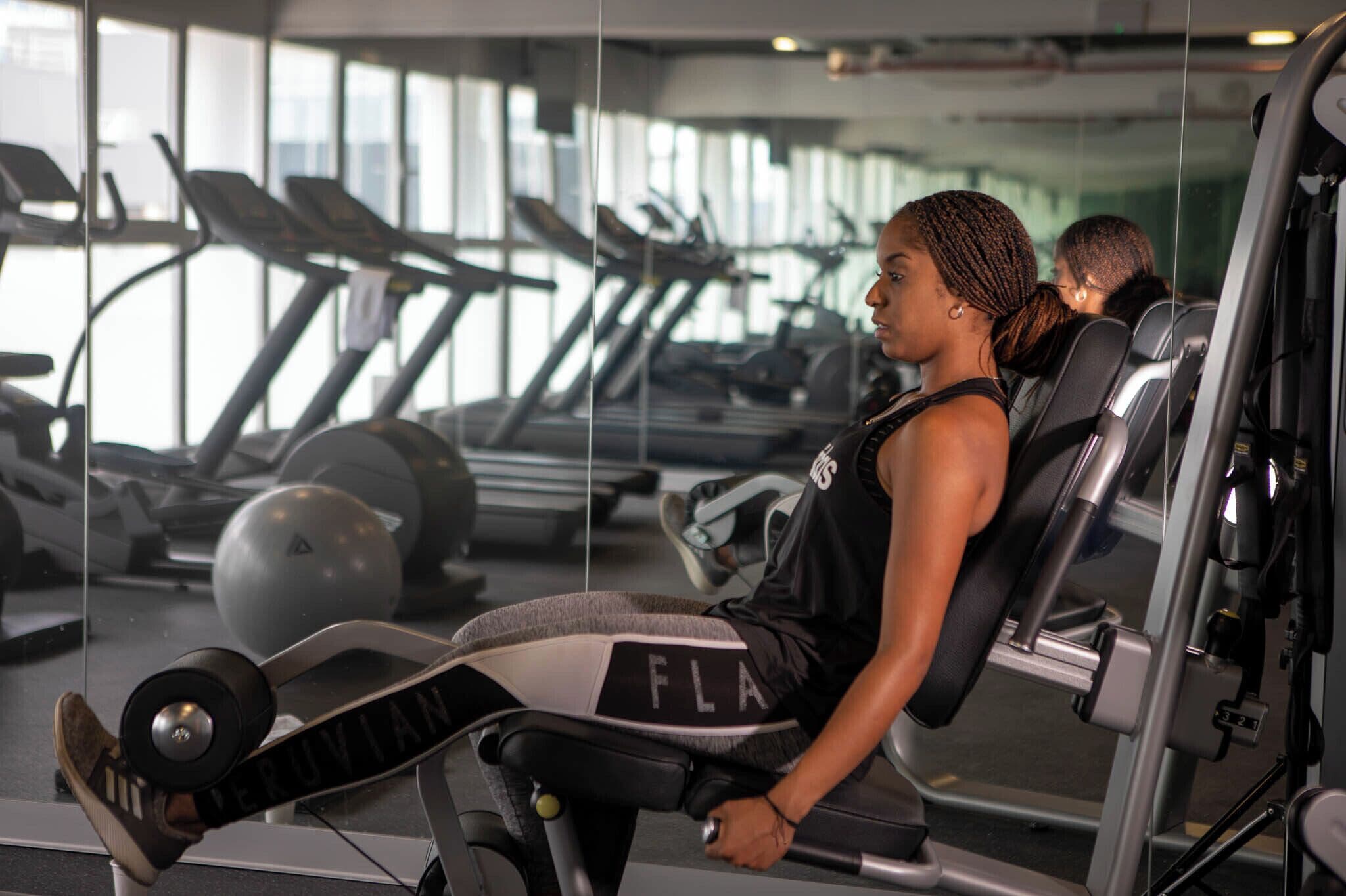 Un gimnasio con equipo de ejercicio, incluyendo una prensa de banca y una cinta de correr.