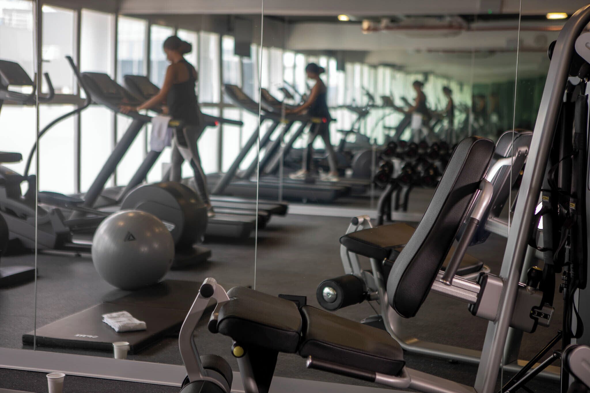 A gym with treadmills, exercise balls, and weight machines.