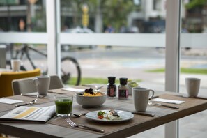 A dining table with a meal, cups, and a newspaper. - Casa Andina Premium San Isidro (Lima)