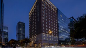 Een modern hotel met een glazen gevel, meerdere verdiepingen en een opvallende entree.