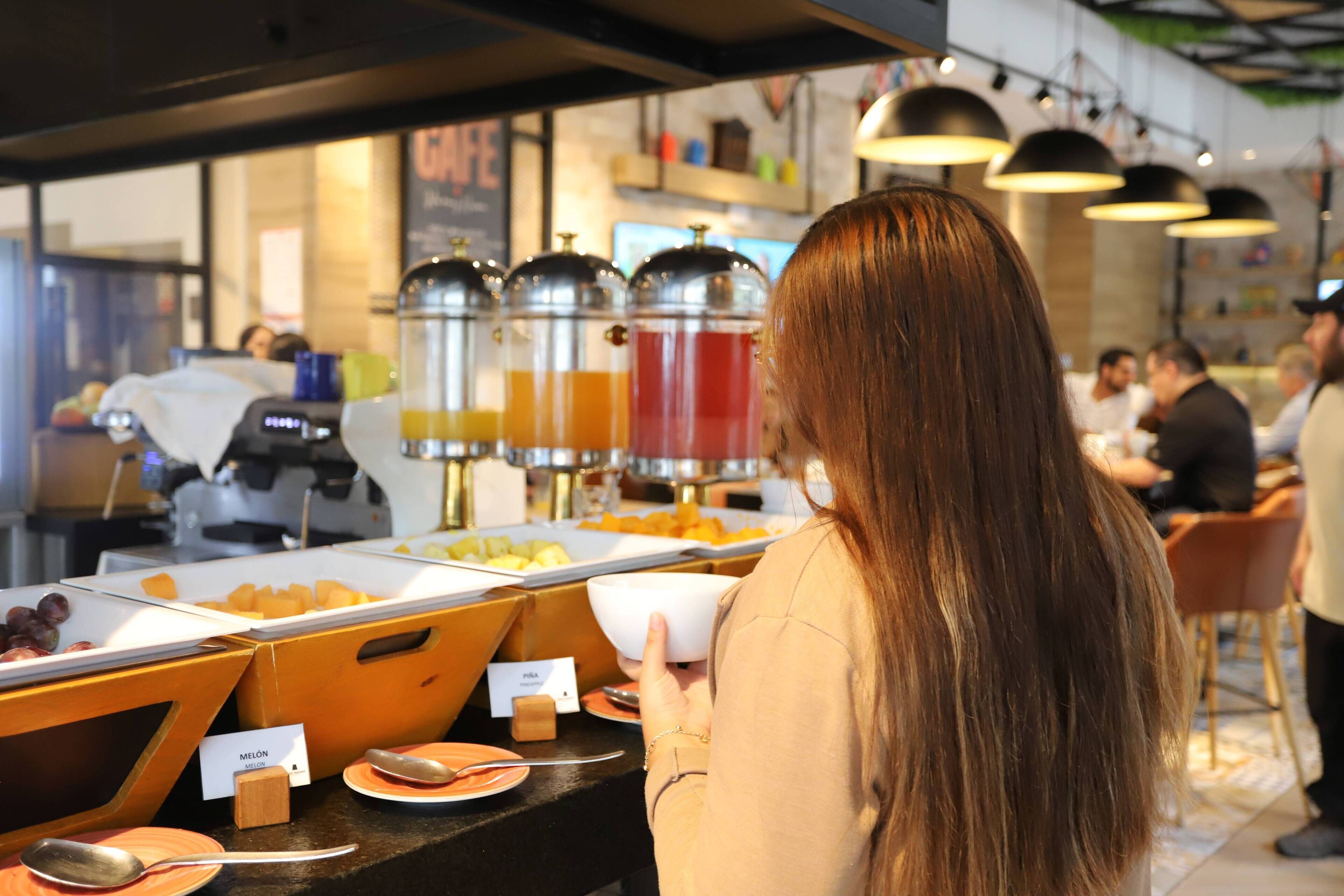 Zona de bufé con diversas opciones de comida y una estación de café.