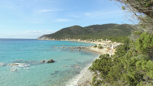 A coastal landscape with clear turquoise waters, rocky shoreline, and a forested hill in the background. - Villa dell'Arte, on the beach of Porto Sa Ruxi, Villasimius (Porto Sa Ruxi)