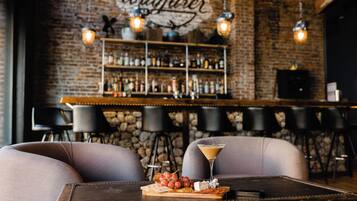 A bar area with a stone wall, hanging lights, and a bar counter.