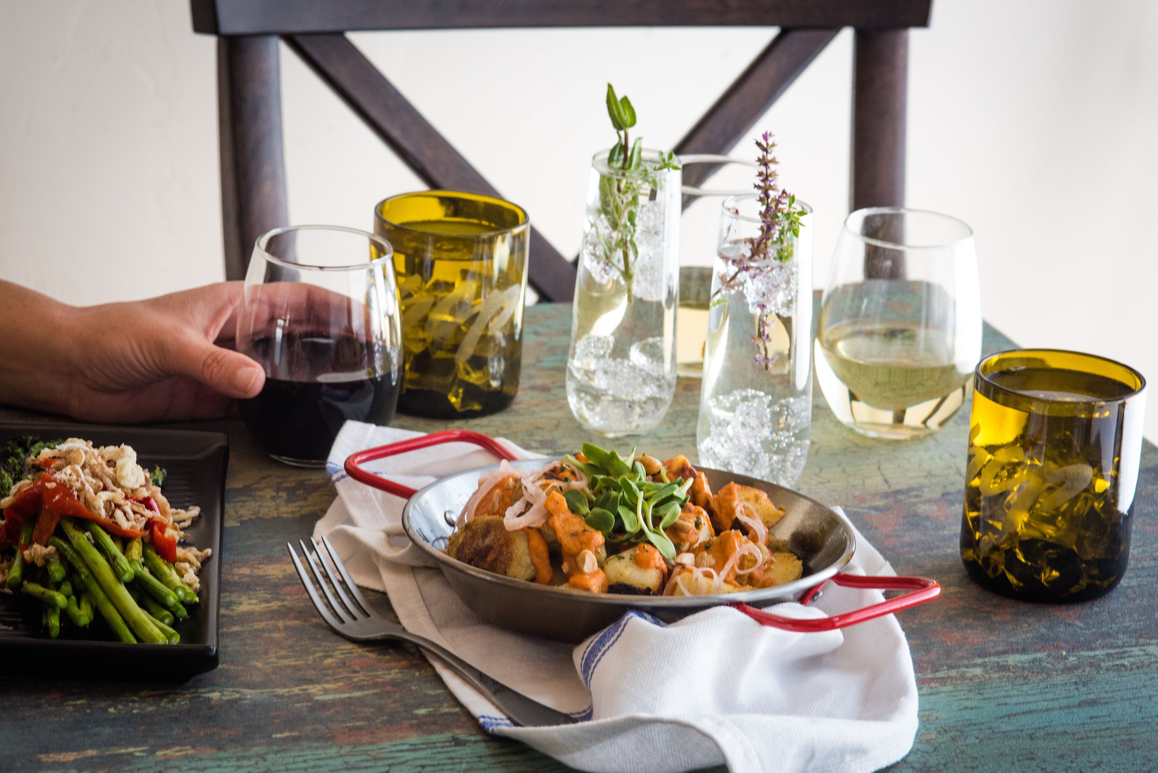 A dining table with a variety of dishes, glasses, and a bottle.