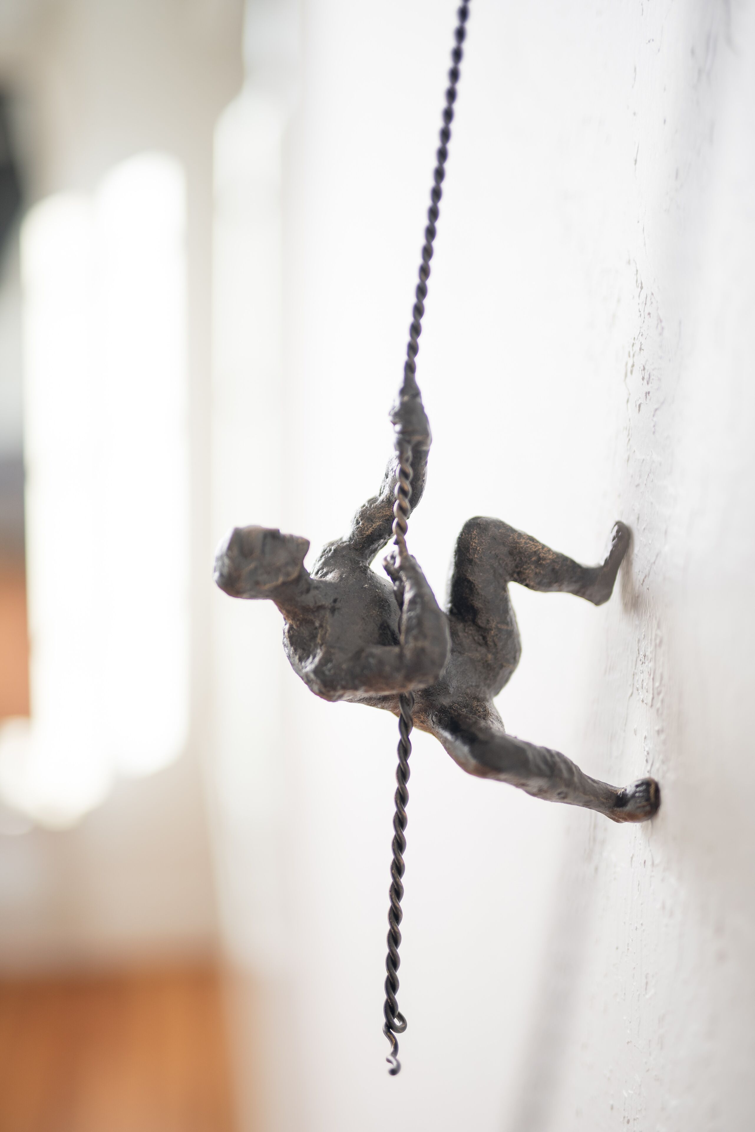 Une sculpture représentant une personne en train d’escalader une chaîne.