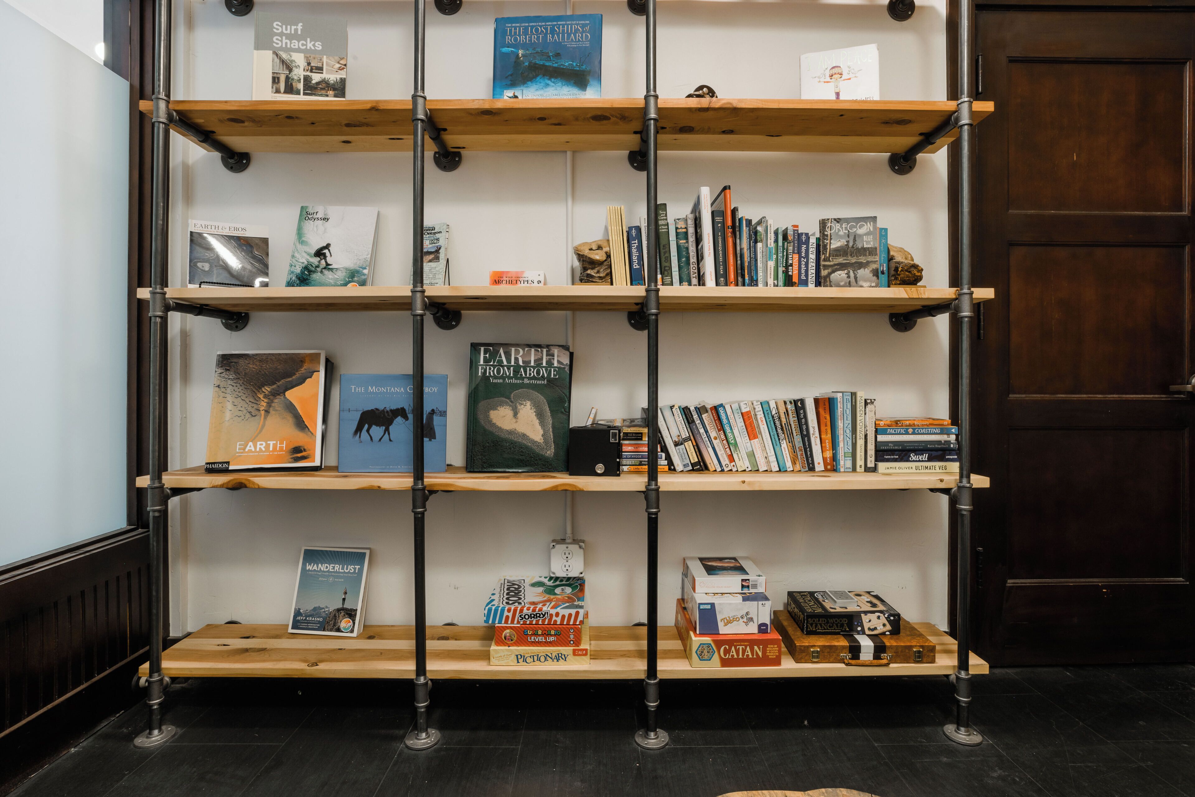Une bibliothèque remplie de livres et de jeux de société.