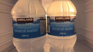 Dos botellas de 500 ml de agua mineral natural Kirkland Signature en un refrigerador.