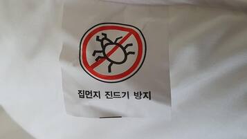 A white fabric with a label featuring a prohibition sign and Korean text.