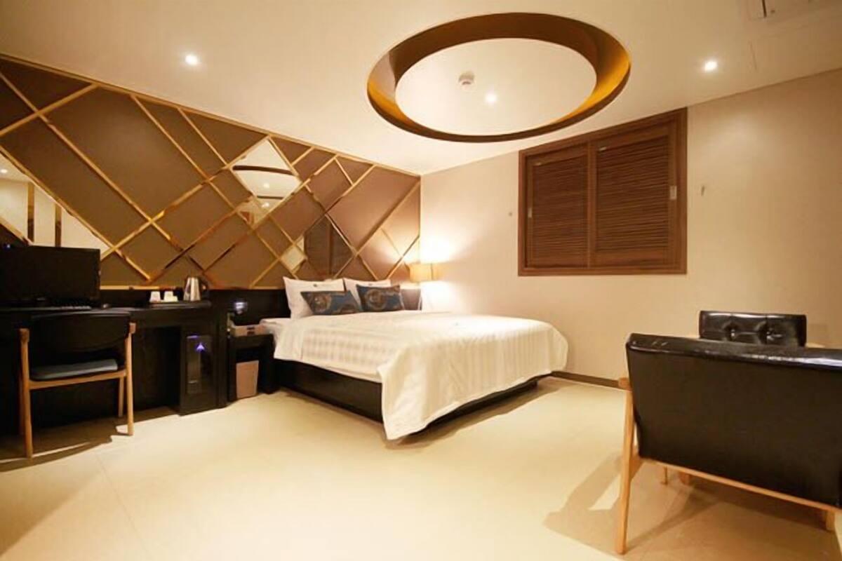 A modern bedroom with a bed, a desk, and a chair.