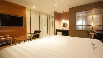 Habitación de hotel con una cama grande, un escritorio, una silla, un televisor y una ventana con persianas.