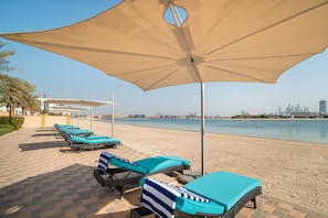 Plage privée, sable blanc, chaise longue, parasol