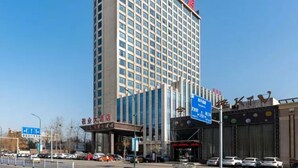 Ein hohes Hotelgebäude mit einem markanten Eingang und Beschilderung.